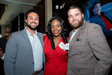 Three people posing in a row
