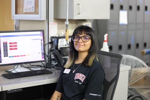 Student employee sitting by a desk