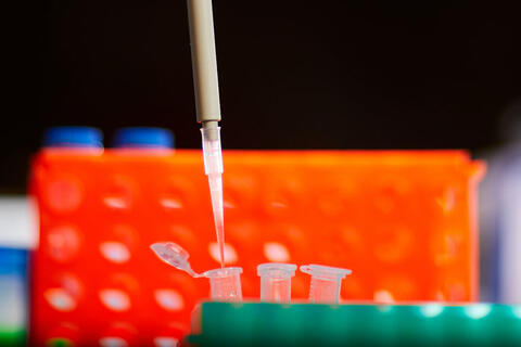Long thin needle-like pipe close to a series of test tubes