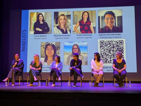 Panel of women sitting on stage