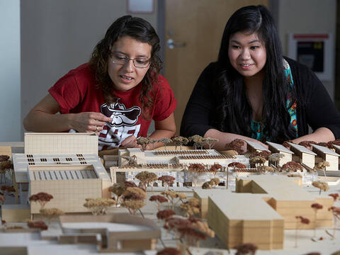 Two students looking at an architectural model