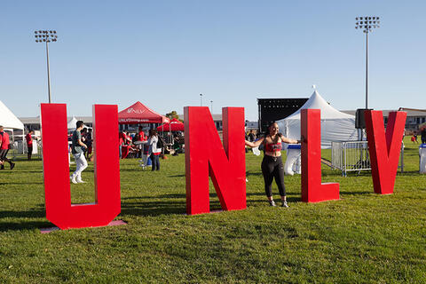 large UNLV letters with person standing next to it