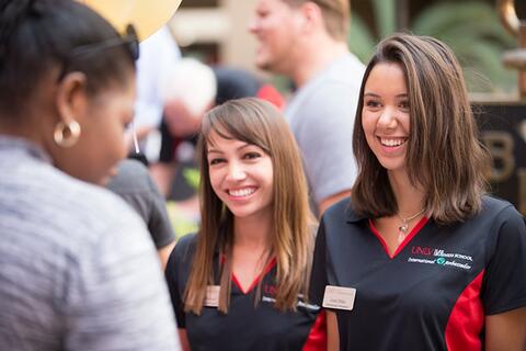 Two business majors with black polo shirts on UNLV campus.